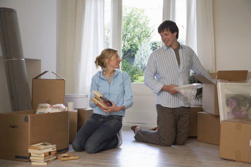 Packed moving boxes and protected furniture in a Southall home