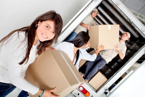 Movers transporting office furniture through a commercial building